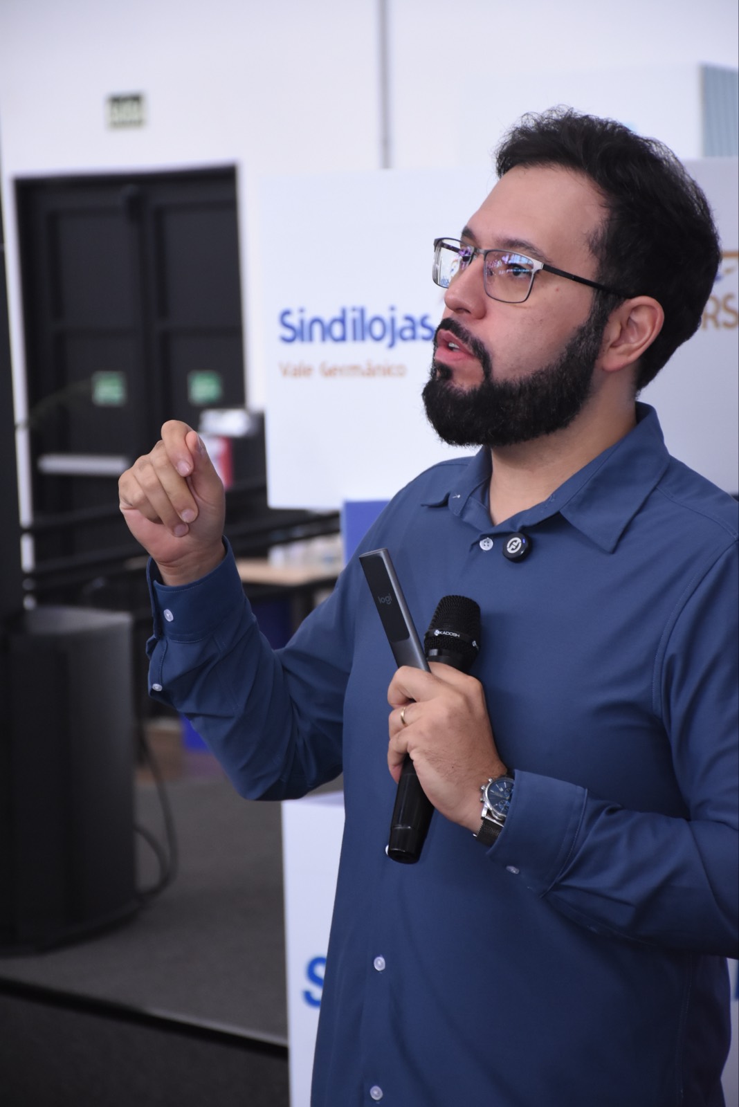 Calebe Salvia, da Implementoria Empresarial, fala ao microfone durante palestra para lojistas no Sindilojas RS Vale Germânico