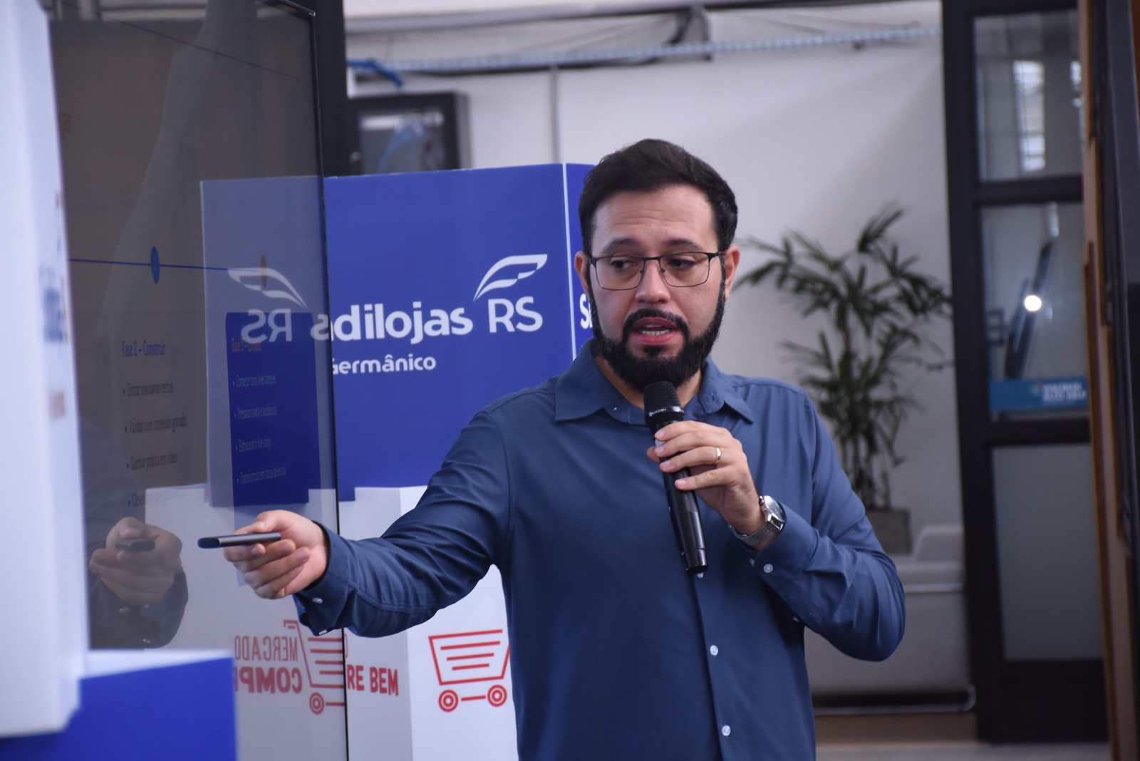 Calebe Salvia aponta para a tela durante uma apresentação